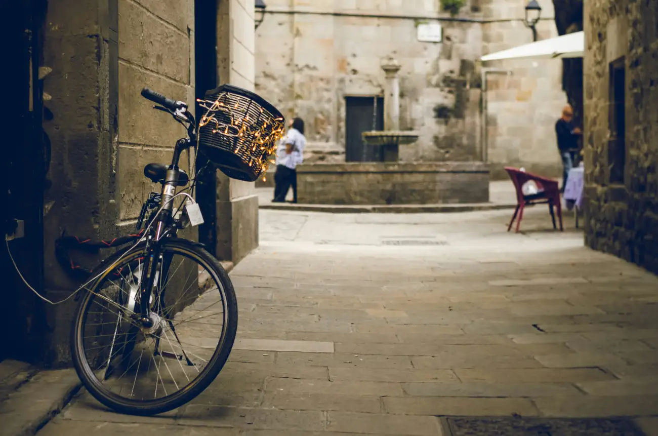 Quiet medieval plaza in Barcelona's Gothic Quarter with a vintage bicycle leaning against an old stone wall