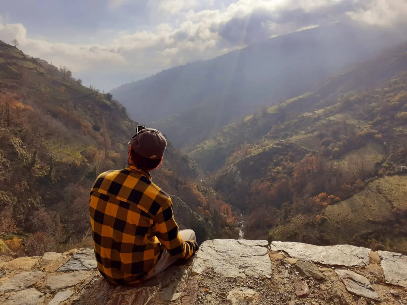 Traveler contemplating the panoramic Poqueira Gorge and Sierra Nevada valley during an Alpujarra day trip