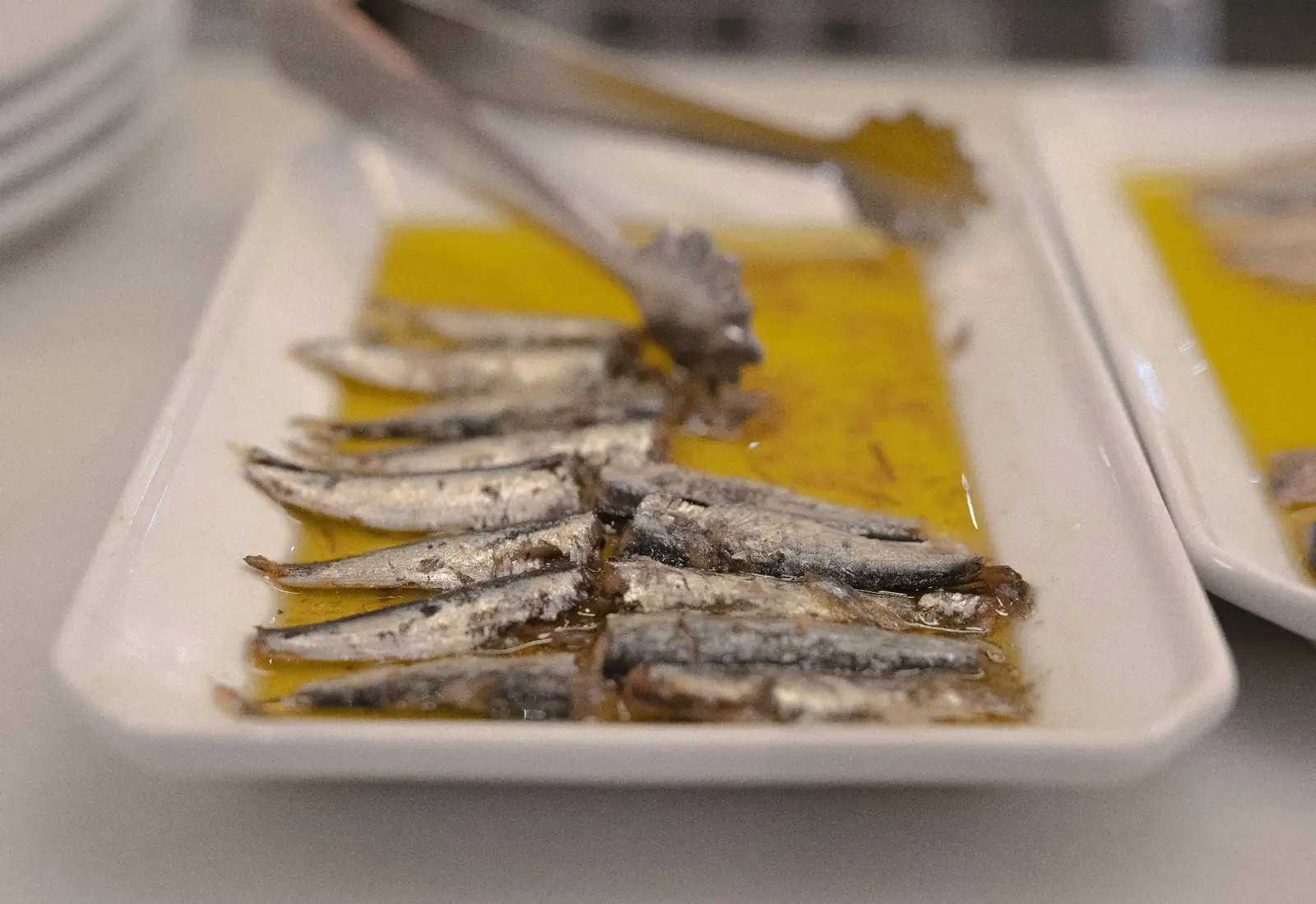 Plato de anchoas vascas tradicionales en aceite de oliva servido como pintxo clásico en San Sebastián