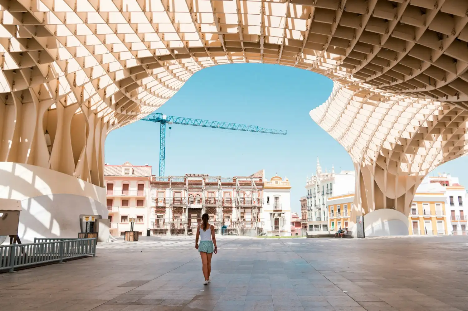 Metropol Parasol wooden structure in Seville with traditional Andalusian buildings framed beneath its arches