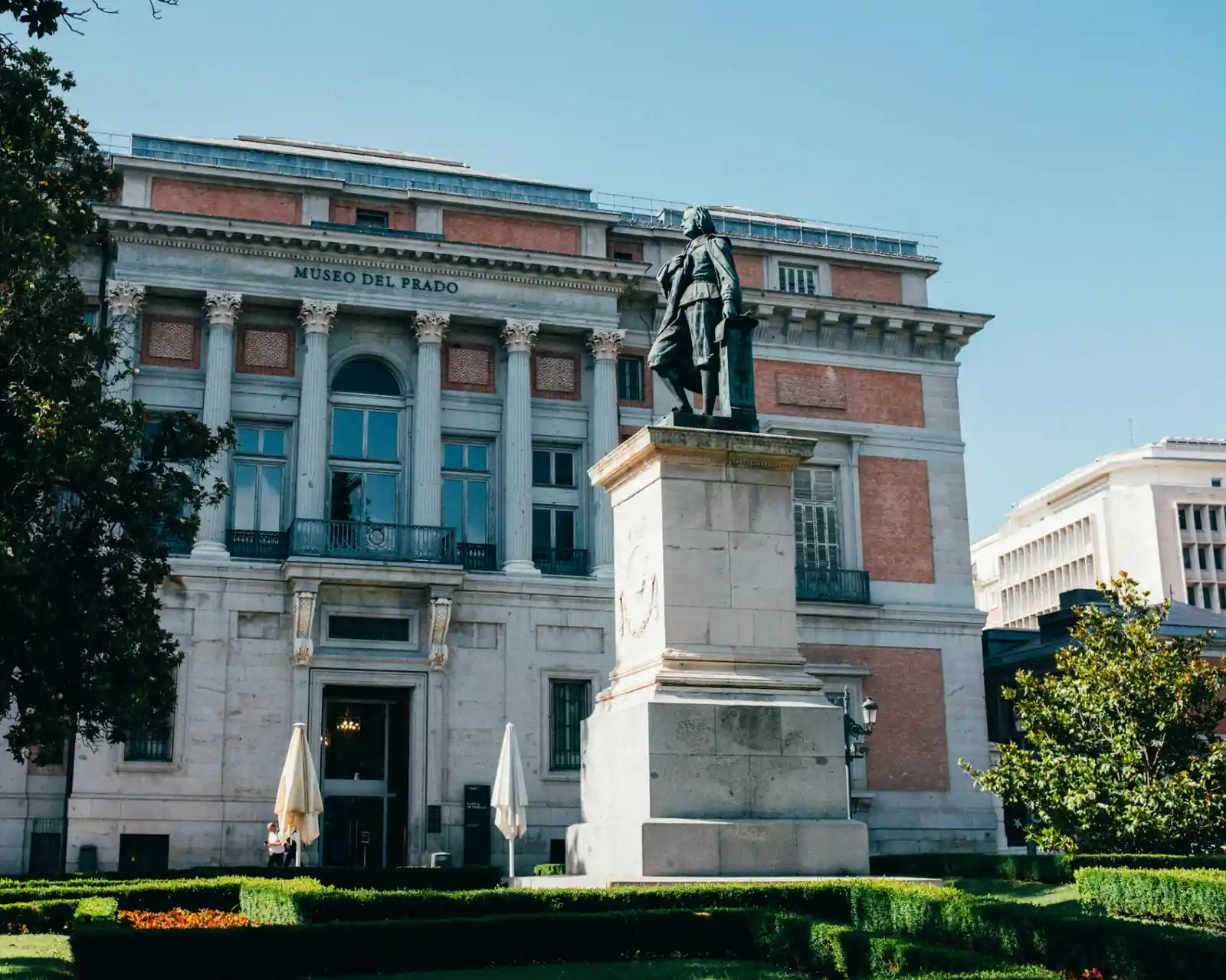 Museo del Prado neoclassical facade in Madrid with the bronze statue of Velázquez at the entrance