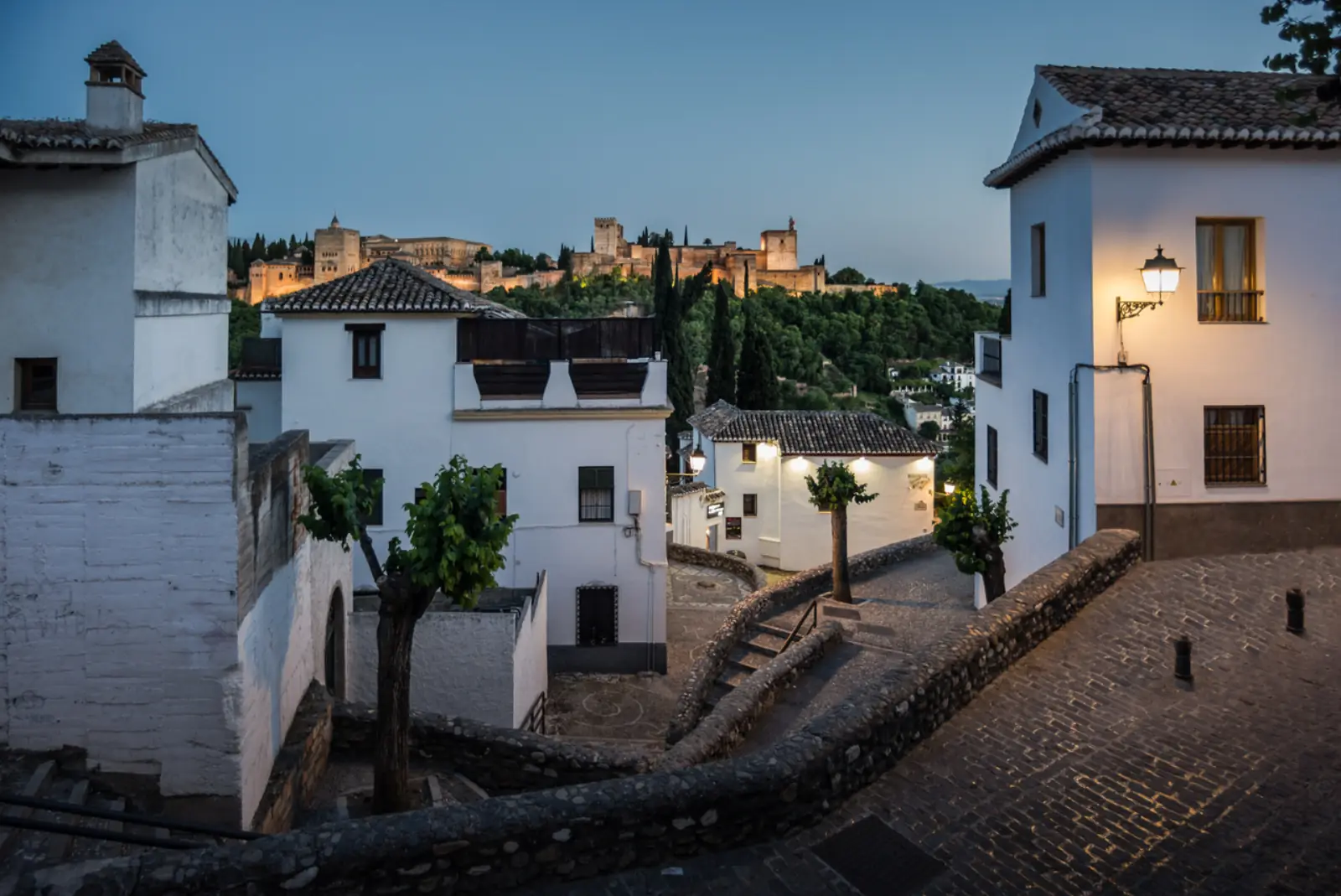 View of the Alhambra at dusk from the whitewashed houses of Sacromonte and Albaicín in Granada