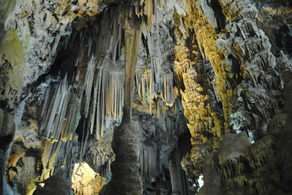 Interior of Saint Michael's Cave in Gibraltar with dramatic stalactites and warm amber lighting