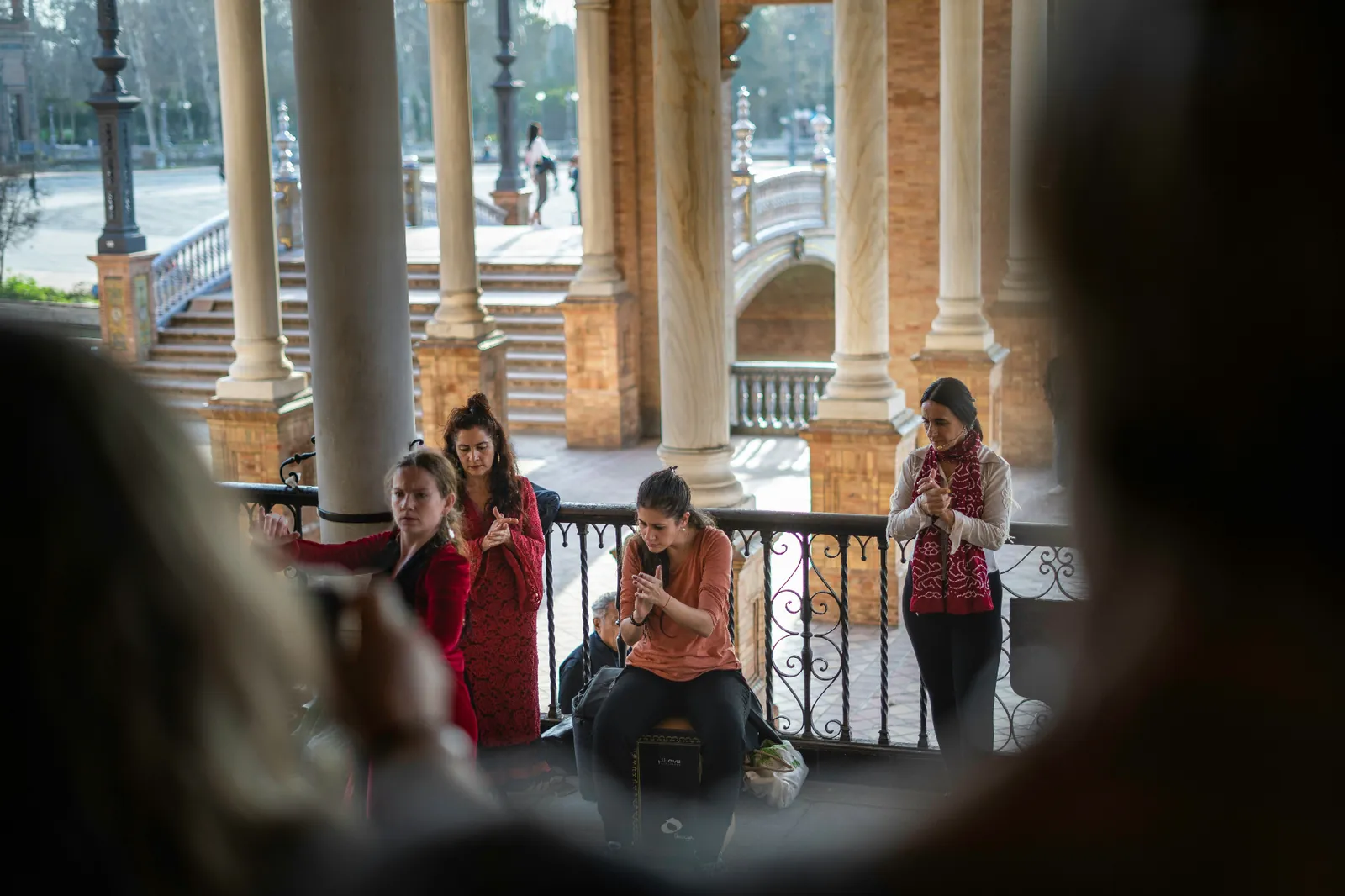 Professional flamenco dancer in a red dress performing in an intimate Triana tablao with guitarist in the background