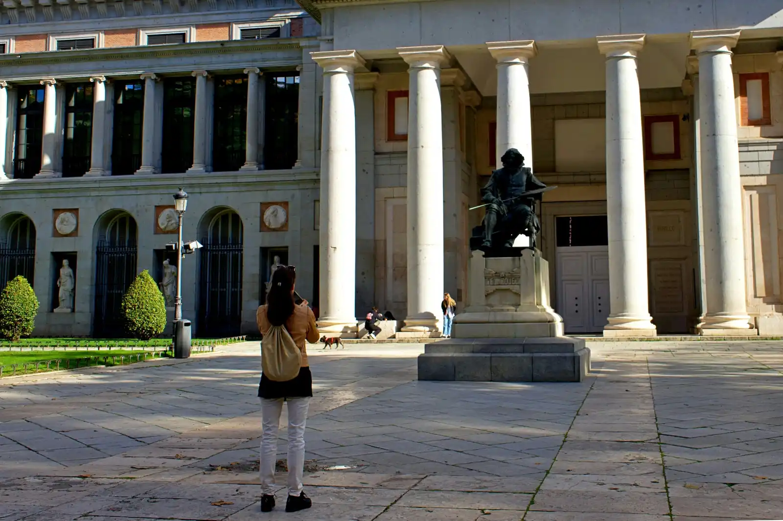 Bronze statue of Diego Velázquez in front of the columned entrance of the Prado Museum in Madrid